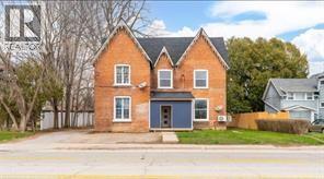 A two-story brick house with a blue door and windows.