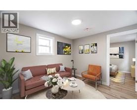 A living room with a couch, a chair, a coffee table, and pictures on the wall.