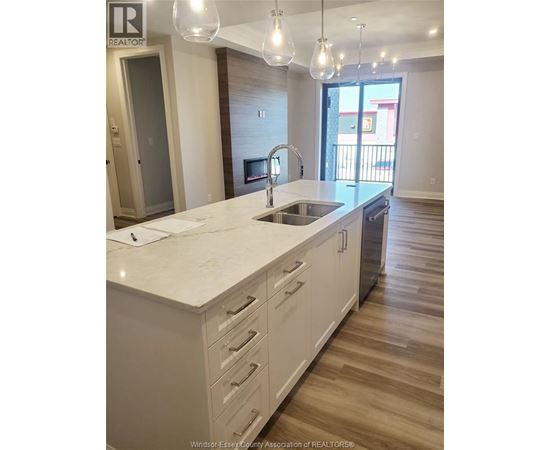 A kitchen with white cabinets and a marble countertop.