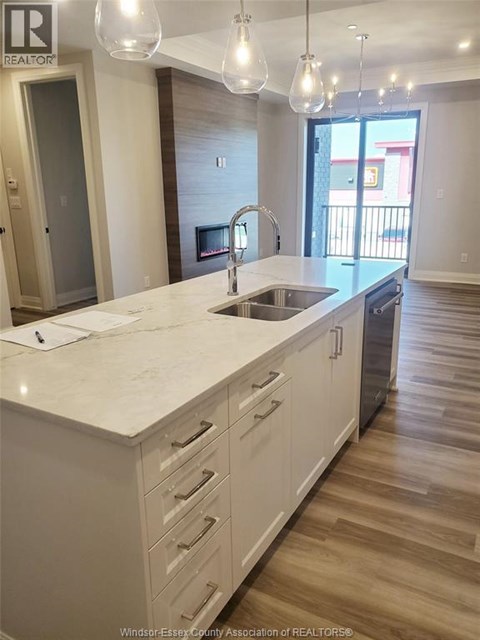 A kitchen with white cabinets and a marble countertop.