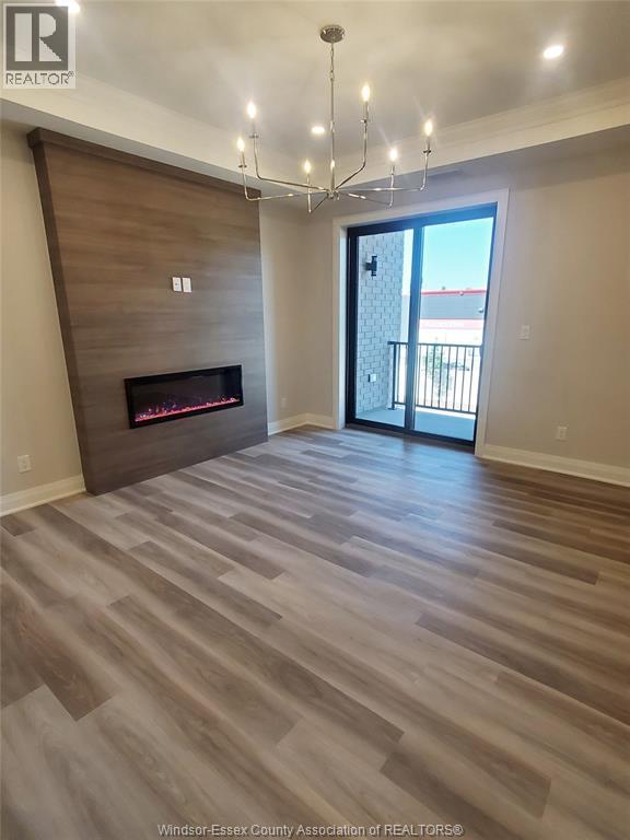 A spacious room with a fireplace and a chandelier.