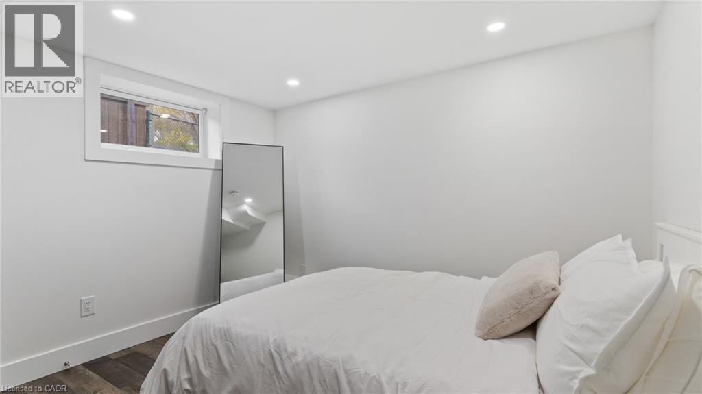 A bedroom with a bed, pillows, and a mirror on the wall.