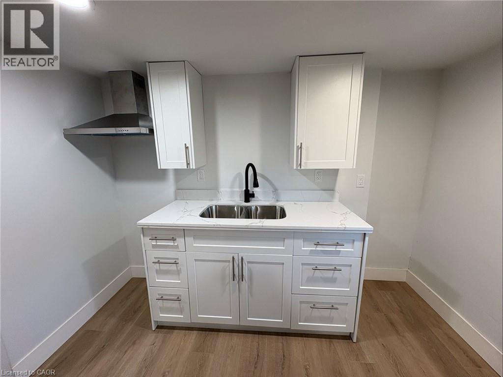 A white kitchen with a sink and cabinets.
