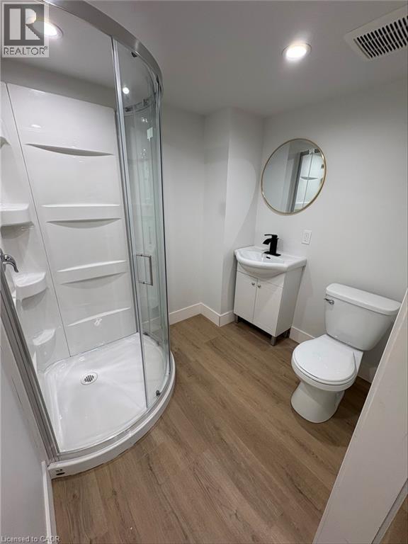 A white bathroom with a walk in shower and toilet.