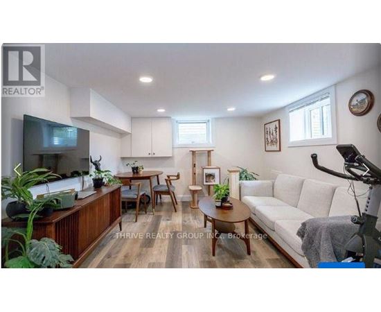 A living room with a white couch and wooden floors.