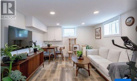 A living room with a white couch and wooden floors.