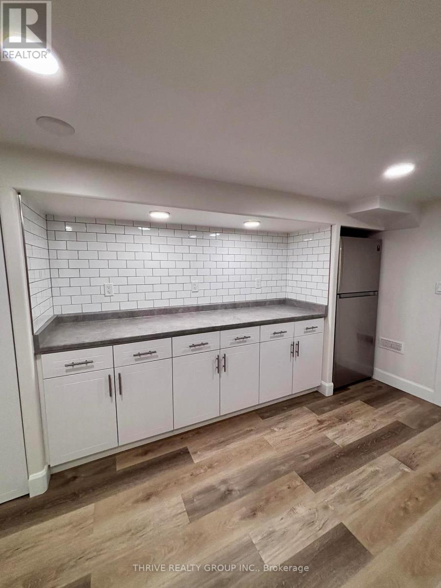A kitchen with white cabinets and a tiled backsplash.