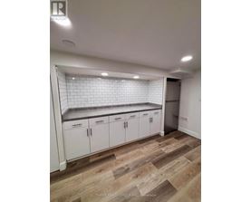 A kitchen with white cabinets and a tiled backsplash.