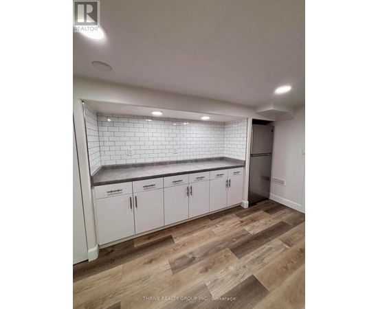 A kitchen with white cabinets and a tiled backsplash.