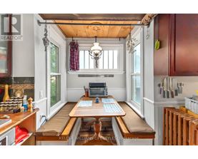 A kitchen with a wooden table and a chandelier hanging from the ceiling.
