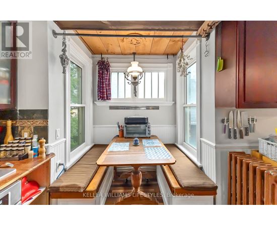 A kitchen with a wooden table and a chandelier hanging from the ceiling.