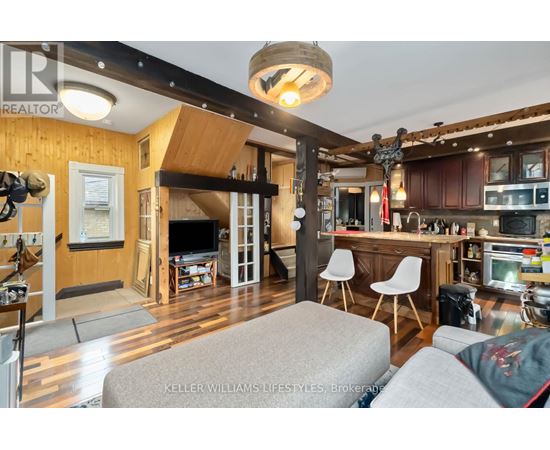 A living room with a grey couch and a wooden ceiling.
