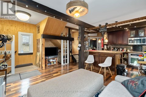 A living room with a grey couch and a wooden ceiling.