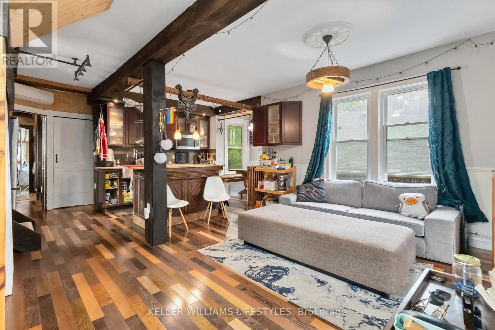 A living room with a grey couch and a wooden floor.