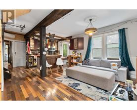 A living room with a grey couch and a wooden floor.