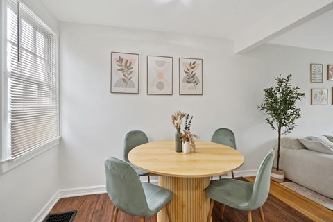 A dining room with a round table and chairs.