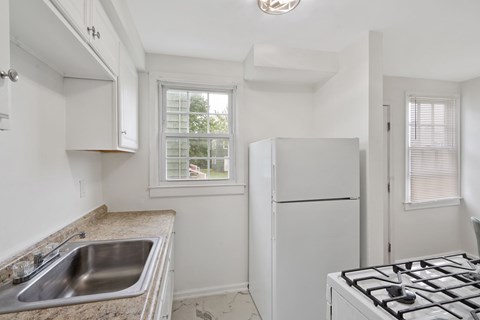 A kitchen with a stove, sink, and window.