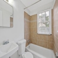 A white toilet sits next to a sink in a bathroom.