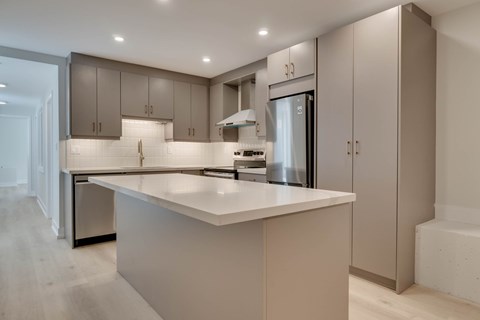 A modern kitchen with a large island and stainless steel appliances.
