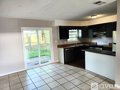 A kitchen with black cabinets and a white countertop.
