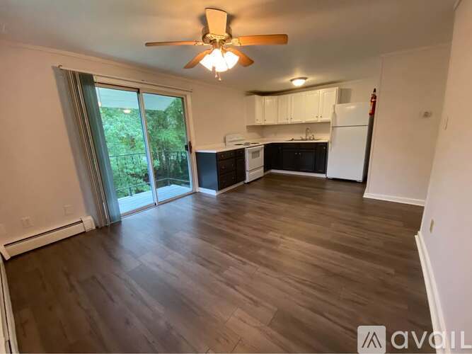 A room with a ceiling fan and sliding glass doors leading to a backyard.