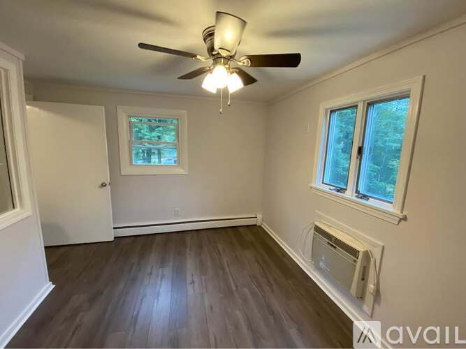 A room with a ceiling fan and a window.