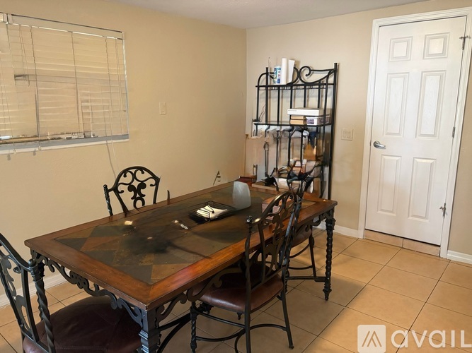 A dining room with a wooden table and chairs.