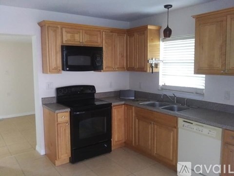A kitchen with wooden cabinets and black appliances.