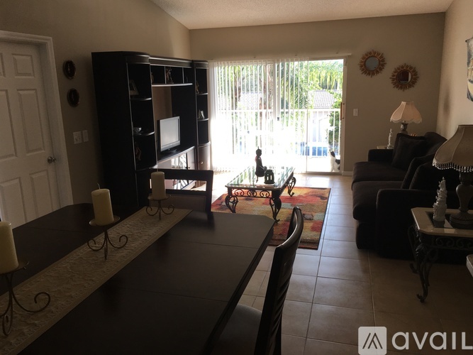 A living room with a black table and a television on a stand.