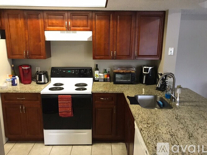 A kitchen with a black stove top oven and a red towel on it.