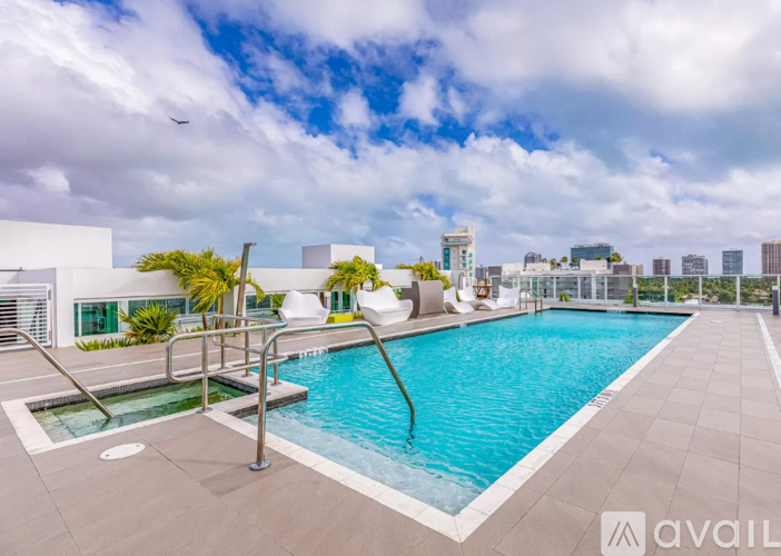 A large outdoor swimming pool with a metal ladder and a sun lounger.