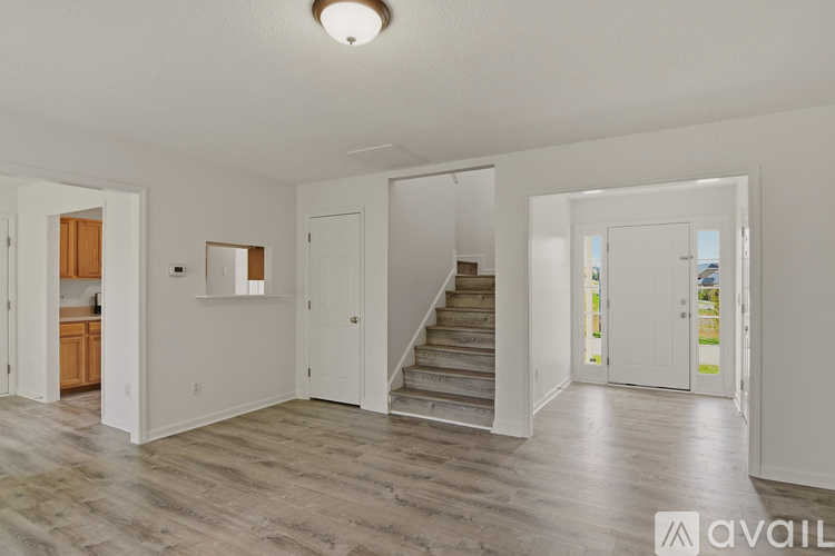 A spacious living area with a staircase leading to the upper floor.
