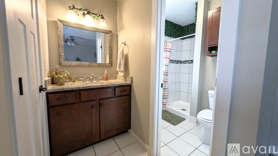 A bathroom with a mirror, sink, and toilet.