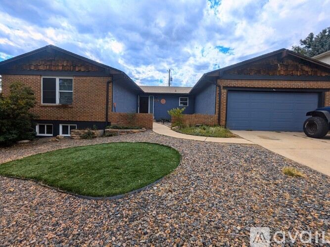 A house with a gravel driveway and a grassy area in front.