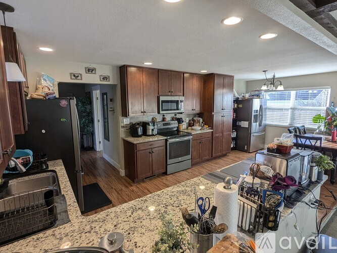 A kitchen with granite countertops and wooden cabinets.