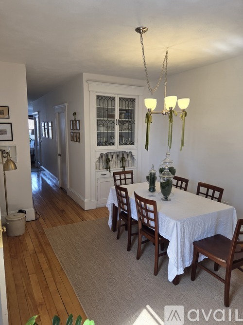 A dining room with a white table and chairs.