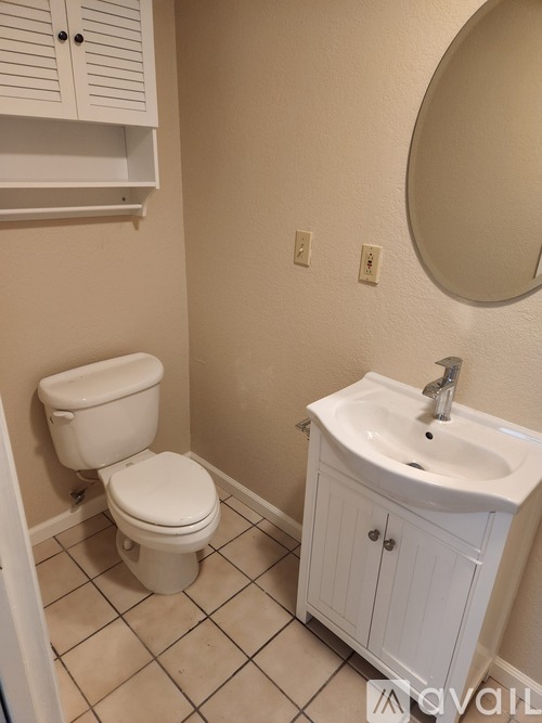 A white toilet and sink in a small bathroom.