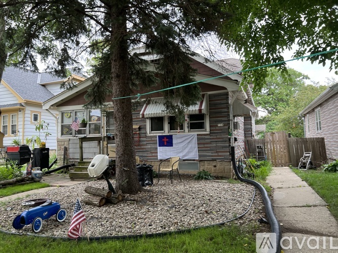 A tree in a yard with a house in the background.