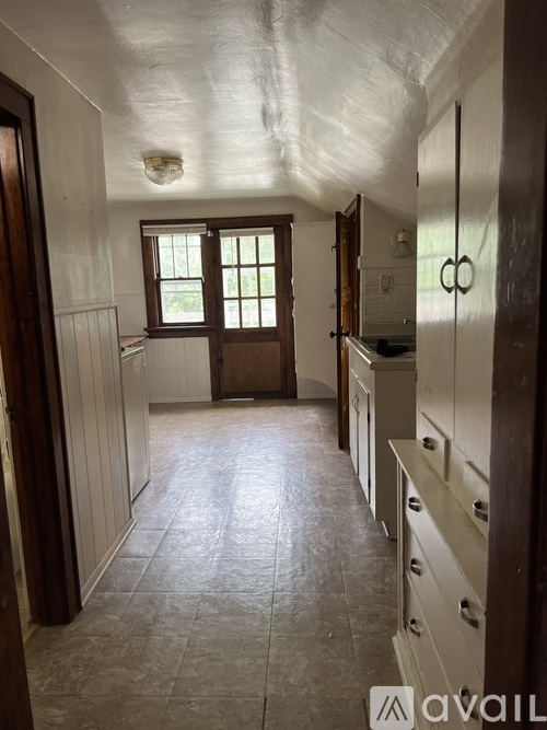 A long hallway with a window and a door on the left.