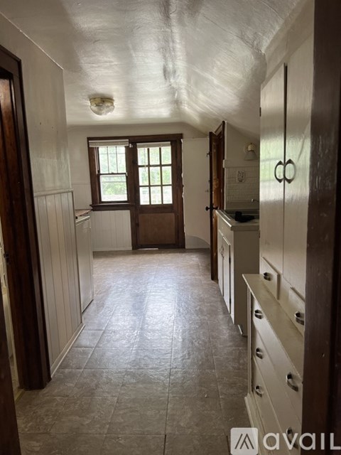 A long hallway with a window and a door on the left.