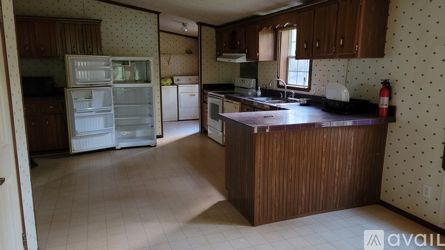A kitchen with a refrigerator, sink, and oven.