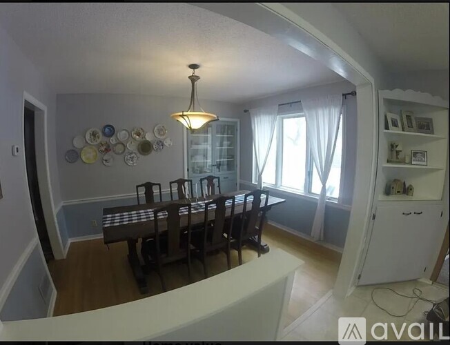 A dining room with a table and chairs.