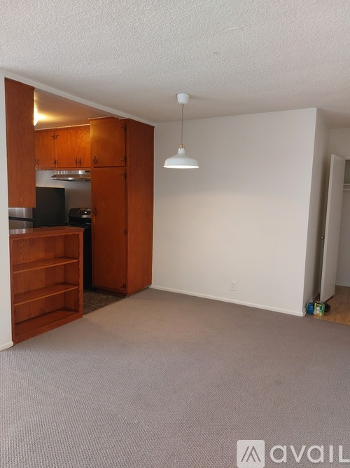 A room with a kitchenette and a large empty space.