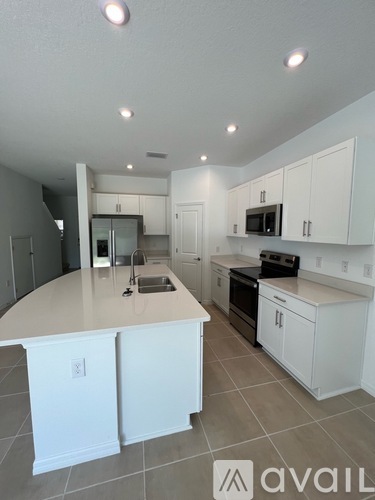 A kitchen with white cabinets and a large island.