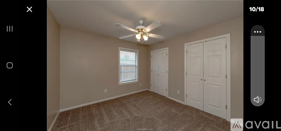 A room with a ceiling fan and two doors.