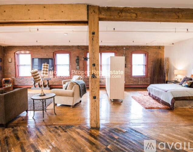 A bedroom with a bed, chair, and a table.