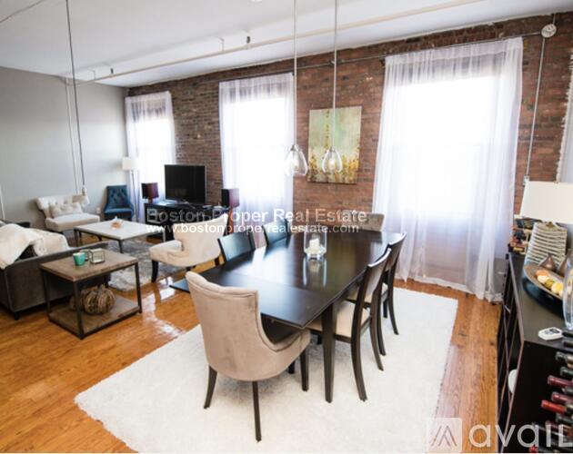 A living room with a black table and chairs.