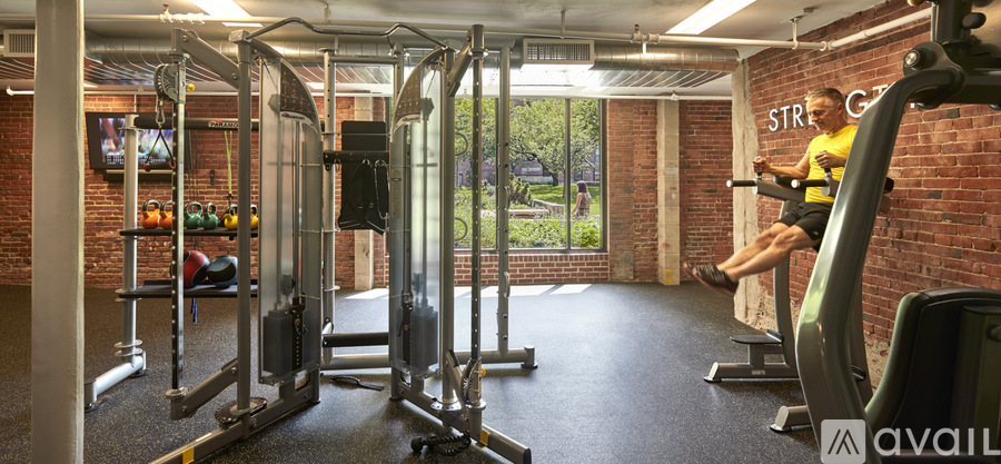 A man is working out on a leg press machine in a gym.