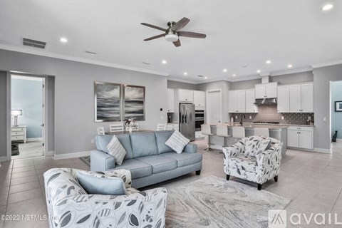 A modern living room with a grey sofa and a patterned armchair.