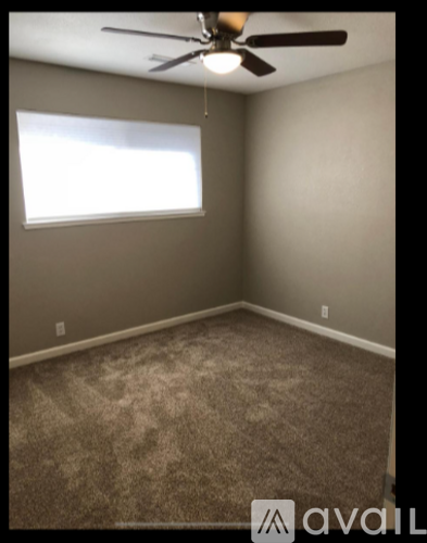 A room with a ceiling fan and a window.
